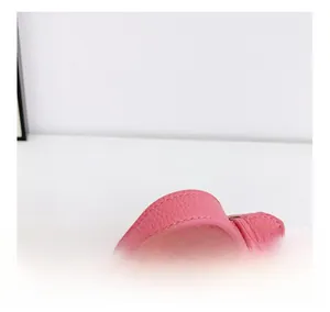 Detail of pink lychee leather handbag handle with precision stitching and round shape