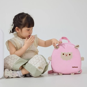 Fillette avec un sac à dos mouton rose, bretelles ajustables et détails de design