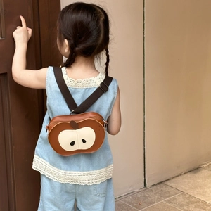 Detail of cute apple-shaped kids backpack with adjustable brown strap and PU leather finish