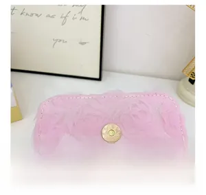 Detail der rosa Spitzenrosen-Textur und des goldenen Metall-Magnetverschlusses der Tasche