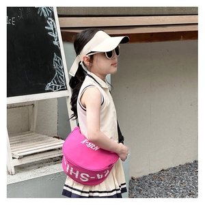 Close-up of bright pink canvas kids crossbody bag with white letter print and sporty design