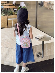 Detailed back view of pink cartoon crossbody bag with crown and colorful pom-poms for kids