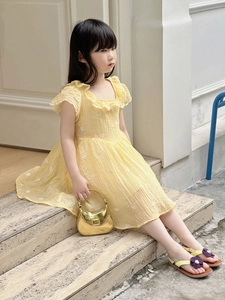 Détail de la robe jaune pour fille avec broderie florale blanche et col à volants élégant