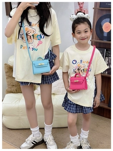 Detailed view of mini Kelly-style kids crossbody bags with golden twist locks in blue and pink