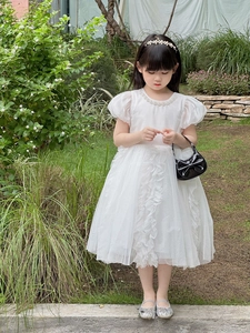 Detail of white girls' princess dress with puff sleeves and layered mesh skirt