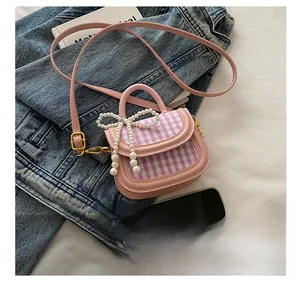 Detail der rosa Mini-Mädchentasche mit Perlen-Schleife und Handy zum Größenvergleich
