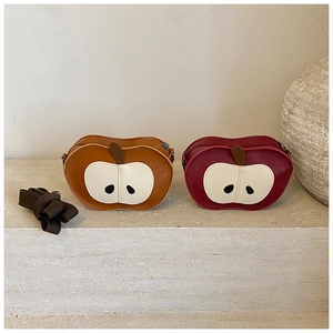 Detail of apple-shaped crossbody bags in tan and burgundy with woven shoulder straps