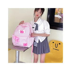 Detailed view of pink plaid backpack with 3D bows worn by schoolgirl model