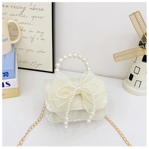 Detail of sequins on cream fabric bag with organza bow and pearl handle beads