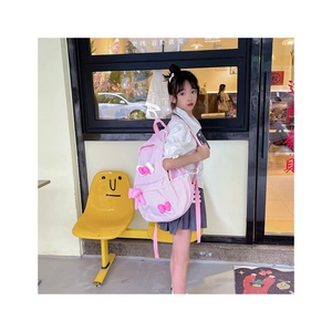 Detailed view of pink plaid kids backpack with decorative bows in a street setting