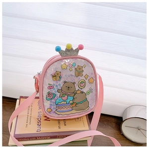 Pink sequined kids crossbody bag with bear print and crown pom-poms on books