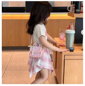 Detailansicht der rosa karierten Kindertasche mit Perlenbogen und verstellbarem Gurt