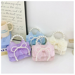 Detail view of mini lace bags with sequin mesh bows and oversized pearl handles