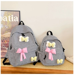 Detail view of plaid school backpacks with cute ribbons in a lifestyle school setting