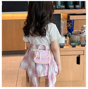 Detail der rosa karierten Kleinkindertasche mit Perlenbogen und Leder-Schultergurt