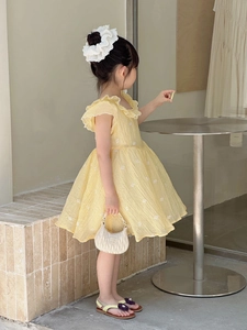 Detail view of yellow A-line cotton-linen dress with floral embroidery and ruffles