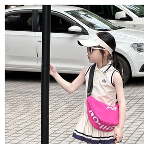Outdoor detail of child sport set with cream polo top and bright pink crossbody bag