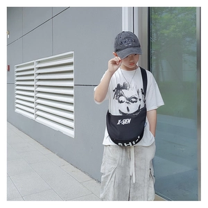 Detail of kids black crossbody crescent bag showing large capacity and bold white lettering