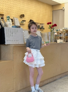 Detail of a pink quilted mini handbag with pleated design held by a young girl