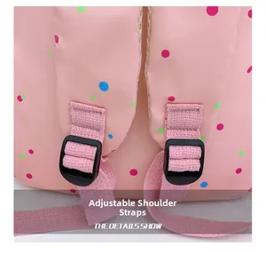 Detailed view of adjustable shoulder strap and durable fabric on pink polka dot backpack