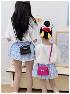 Detailed view of mini litchi grain leather crossbody bags with metal twist lock closures
