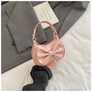 Close-up of a pink mini handbag for girls featuring a large bow and glossy finish