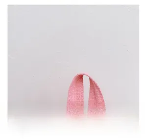 Detail of pink webbing handle on kids backpack featuring colorful polka dot patterns