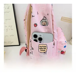 Detail of pink plaid kids backpack showing side pocket storage with a smartphone inside