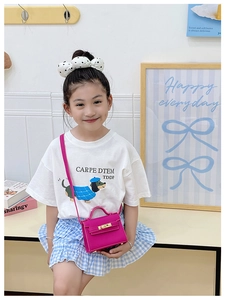 Little girl wearing a magenta pink mini crossbody bag with gold buckle and top handle