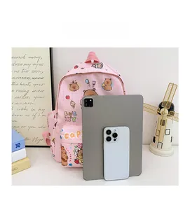 Pink checkered school backpack with cute prints compared to a tablet for size reference