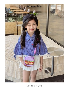 Detail of cute purple silicone hamburger bag for kids with adjustable strap worn outdoors
