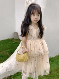 Detailed close-up of cherry embroidery and layered tulle ruffles on girl's sweet dress