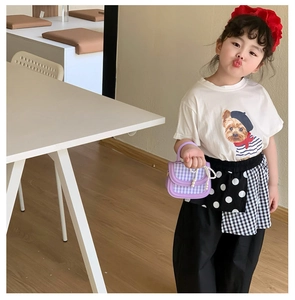 Details einer lila karierten Kinderhandtasche mit Perlenkette und rundem Tragegriff