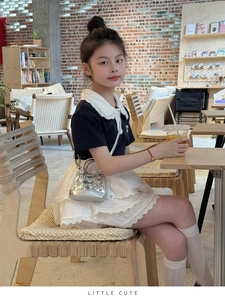 Détail du mini sac à paillettes argenté avec robe polo bleu marine et col en dentelle