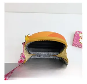 Detail view of the orange cartoon bag interior with dual compartments and pink strap