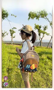 Detail of a khaki excavator backpack for kids showing 3D blue truck and Nana strap