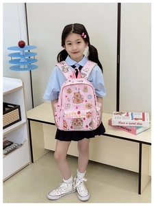Detail view of the pink checkered Capybara backpack worn by a young girl in a bright room