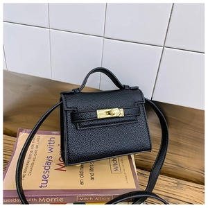 Detail view of the black lychee pattern leather texture and gold twist lock closure