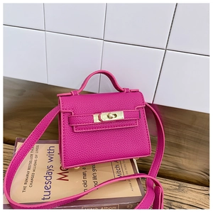 Detail of rose red mini leather bag showing textured finish and metal buckle closure