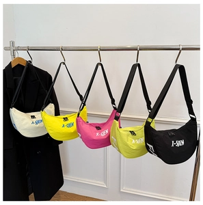 Detail view of five colorful crescent canvas bags with adjustable straps and zipper closure