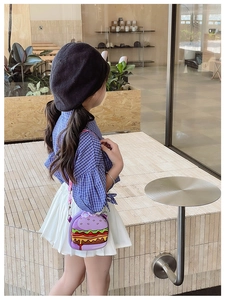 Side view of a toddler wearing the purple cartoon hamburger crossbody bag with floral strap