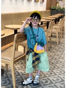 Detail of color-block drawstring mini crossbody bag for kids and stylish summer outfit