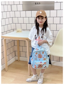 Detail of light blue Capybara cartoon backpack with front pocket and side bottle holder