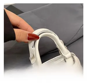 Détail de la poignée confortable et paillettes colorées du mini sac blanc pour enfants