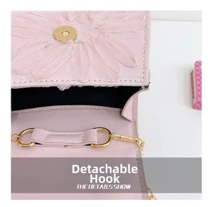 Détail du crochet métallique amovible sur un sac à chaîne en dentelle rose pour filles