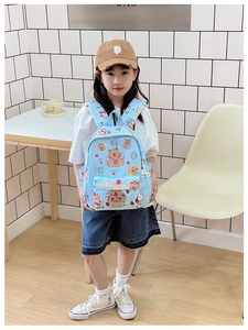 Detail of light blue plaid kids backpack featuring cute capybara print and side pocket