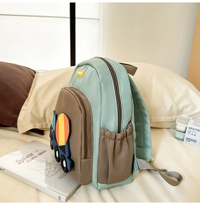Detail showing the side view of green and brown waterproof nylon kids backpack with truck patch