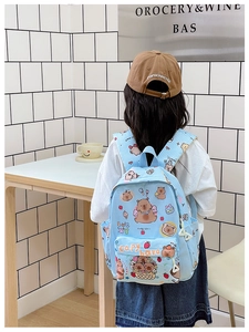 Back view of a light blue plaid schoolbag featuring cute cartoon capybara patterns