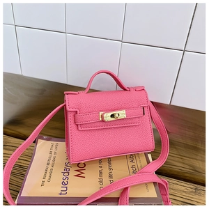 Detail of pink mini trapezoid crossbody bag with litchi grain leather and gold twist lock