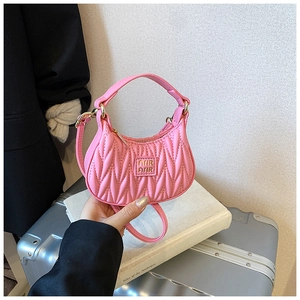 Close-up of pink quilted hobo bag with gold logo and delicate synthetic leather texture